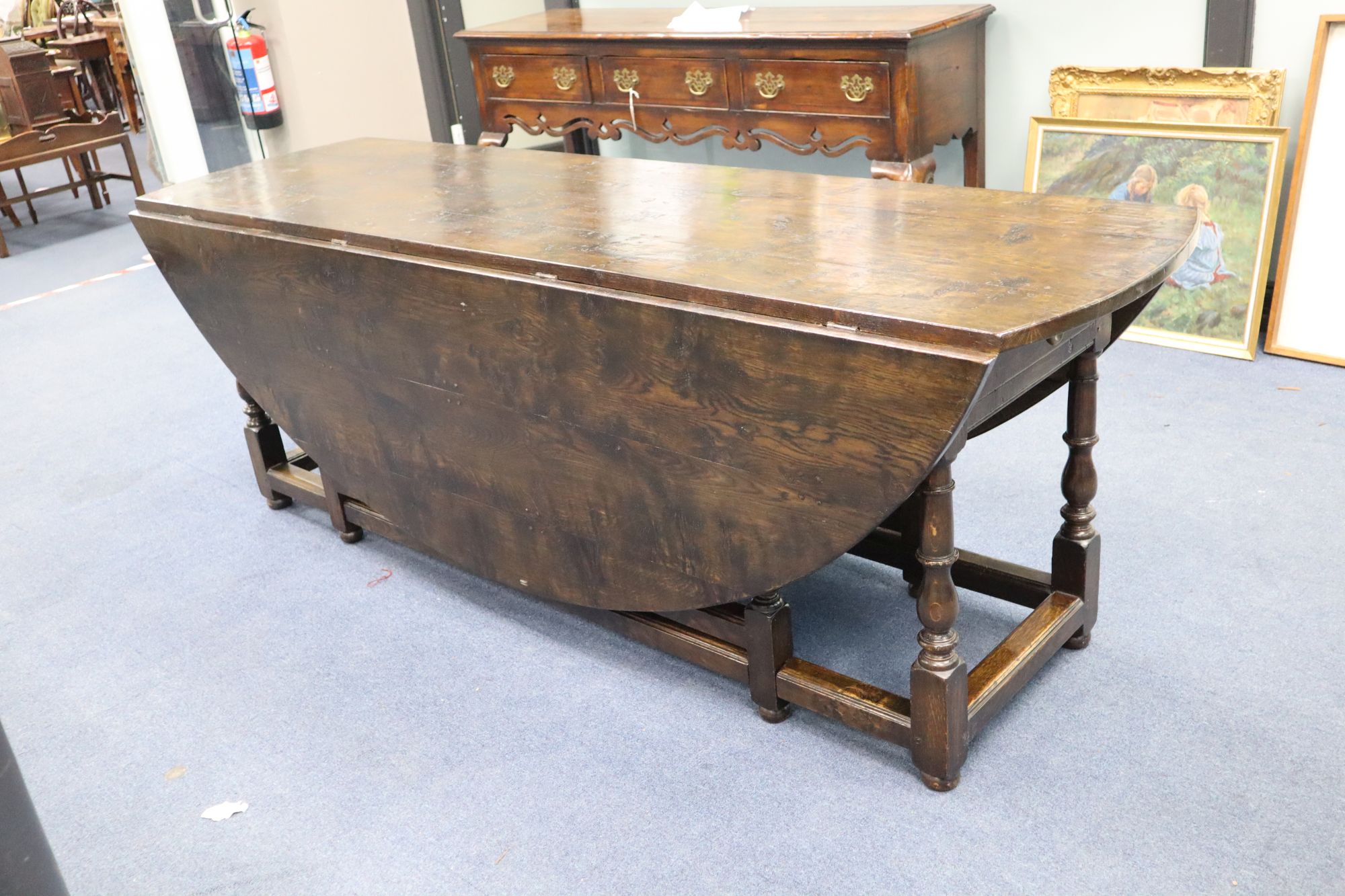 A late 17th century style oak oval topped, double gate leg dining table, width 214cm depth 180cm (extended) height 75cm